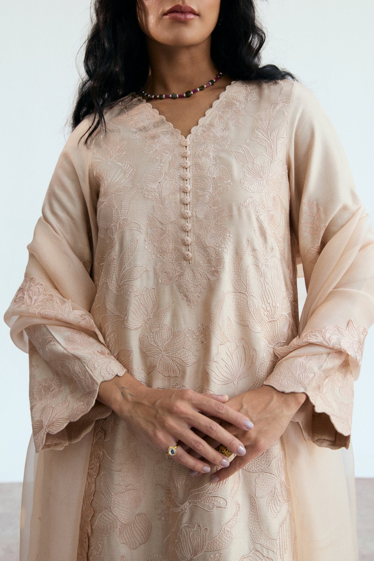 Close-up of monotone floral embroidery and scalloped neckline on a pastel Pakistani 3-piece outfit