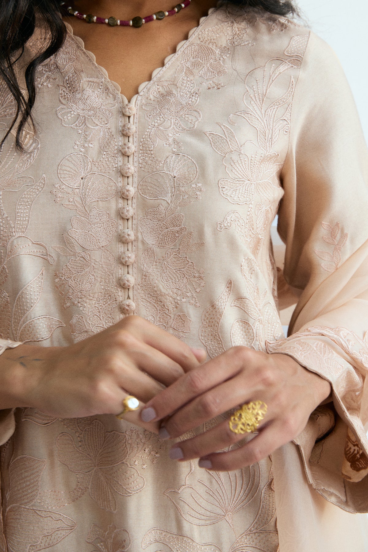 Cutwork detailing on hem and side seams of a peachy pink rayon kameez