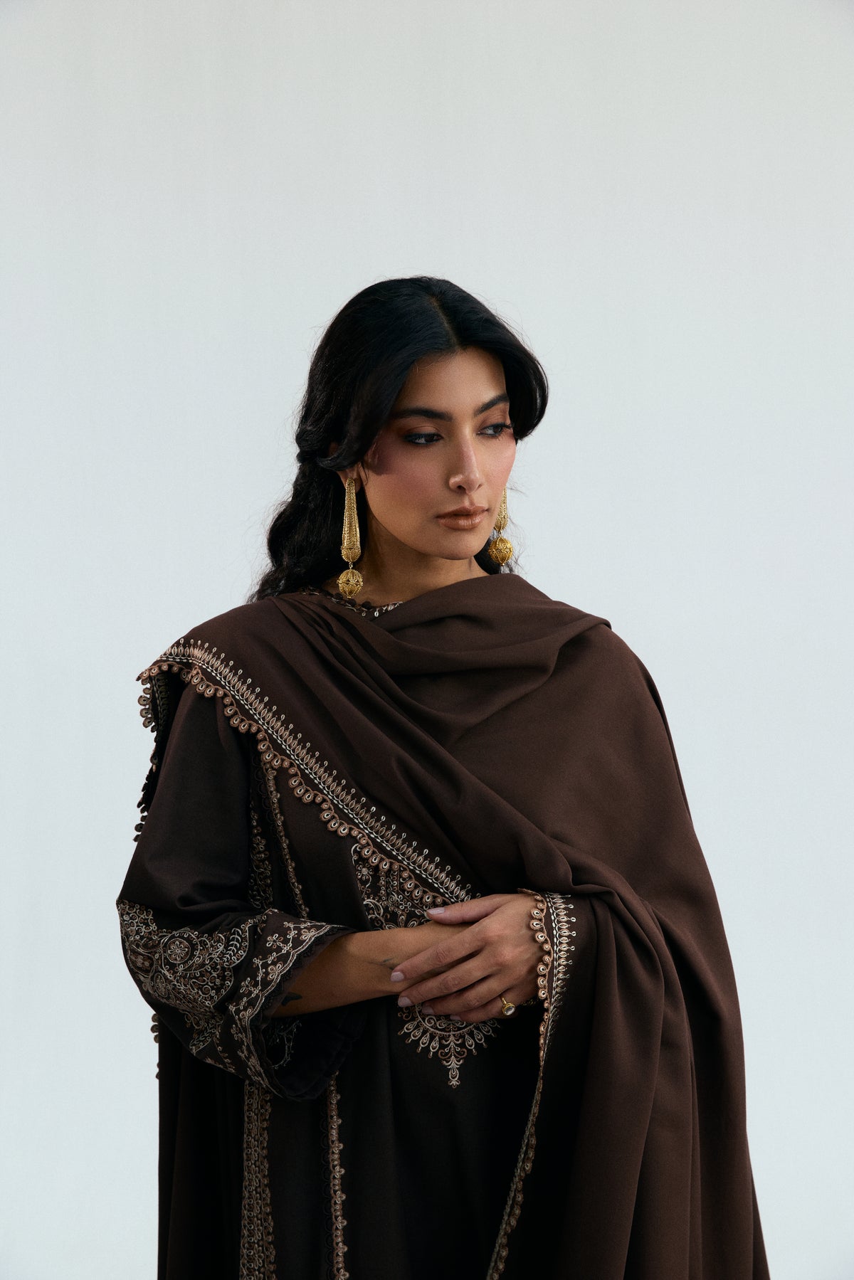 Close-up of the Cocoa Set notched neckline showing button detailing and meticulous floral embroidery framed by side-seam lacework on a chocolate brown designer kameez.