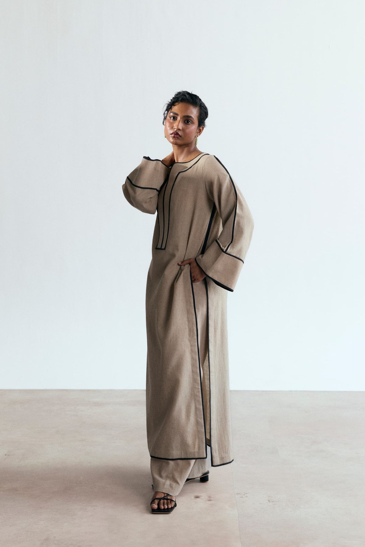 Stone Set — side view of sand beige bell-sleeve Pakistani co-ord with black piping detail UK