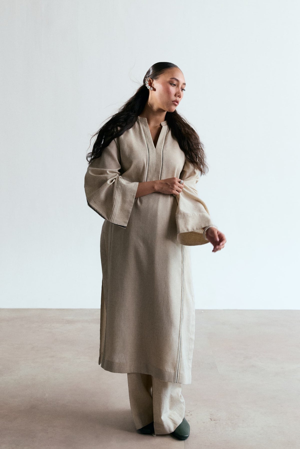 Elegant Pakistani kurta outfit in oat beige linen-cotton — minimalist designer casual wear with black lace detailing on sleeves and side panels