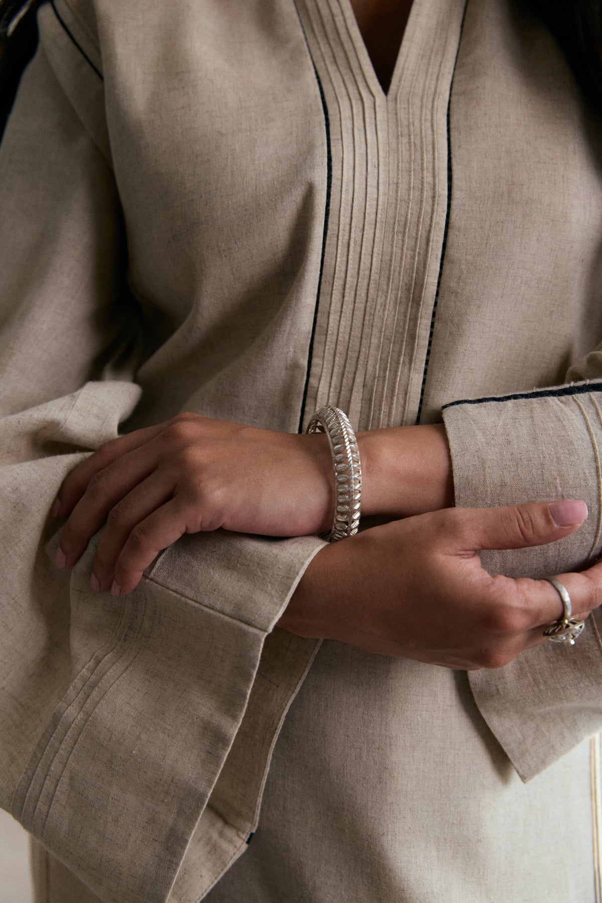 Modern Pakistani linen-cotton oat kurta with black lace sleeve inserts and wide-leg matching trousers — Mannam luxury pret