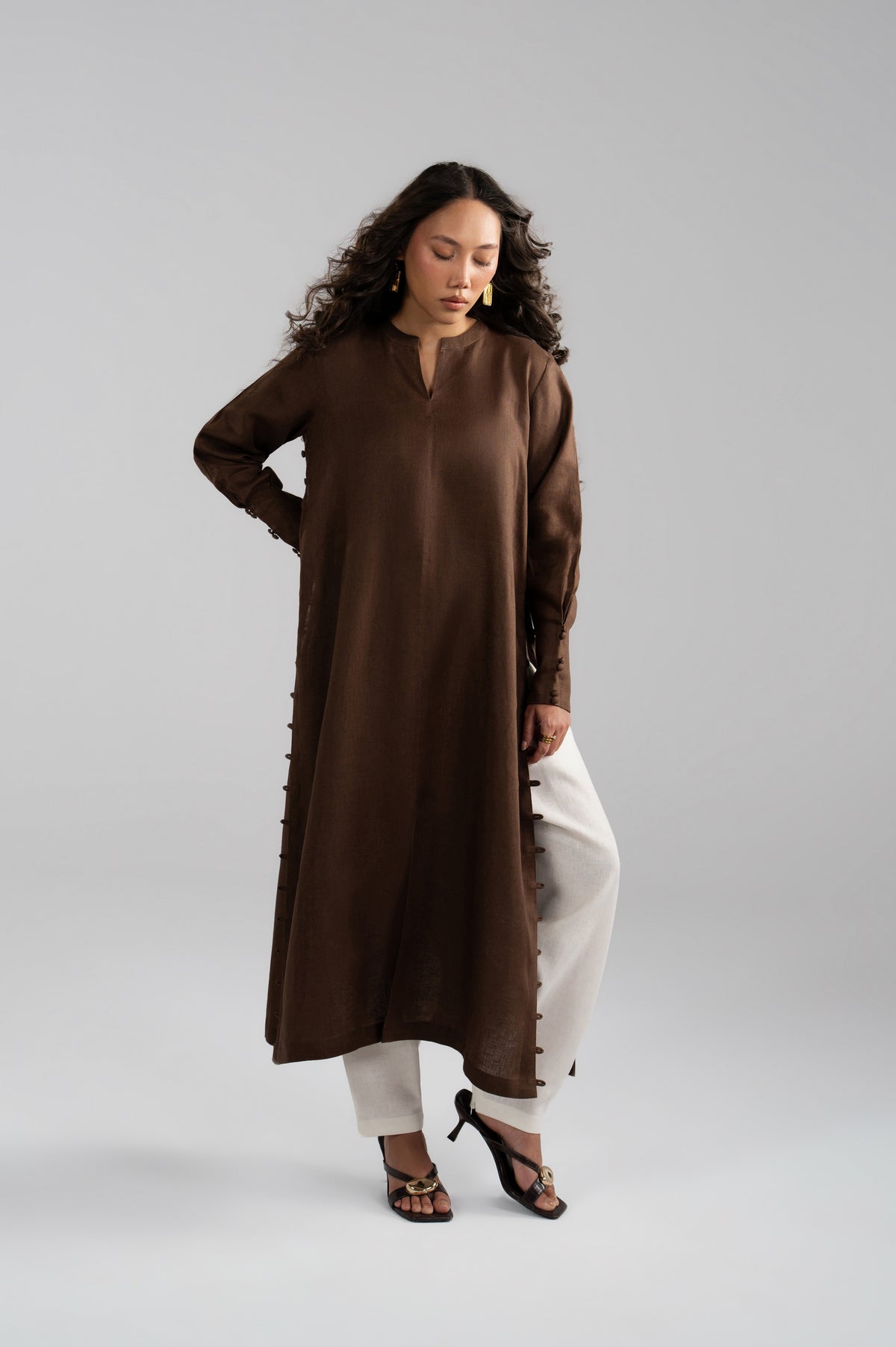 Gentle pose while wearing a brown and white contrast shalwar kameez