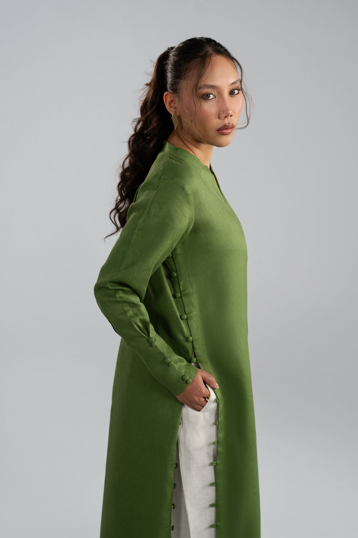 long green dress and white shalwar, hands in pockets