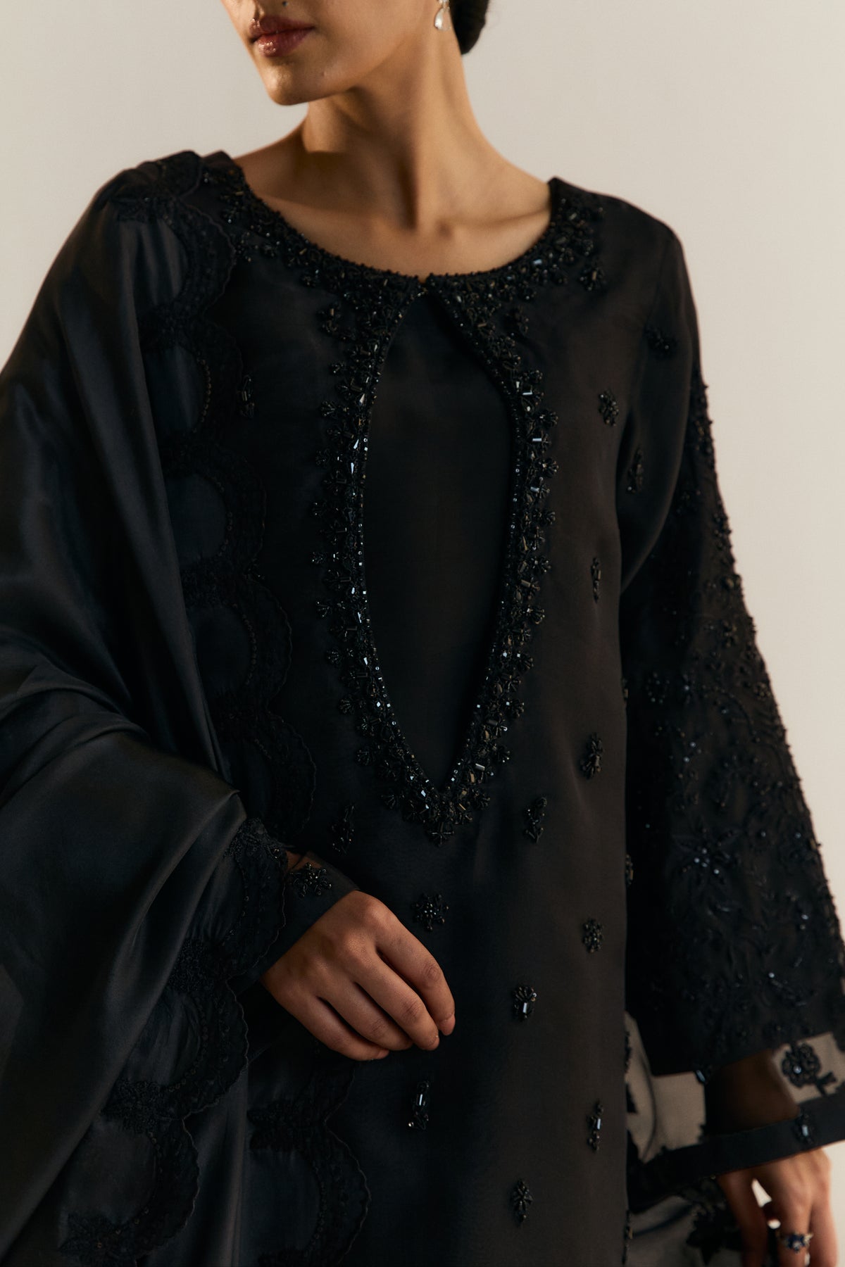 Modern black Pakistani formal attire — designer organza kameez with deep keyhole neckline and floral beadwork