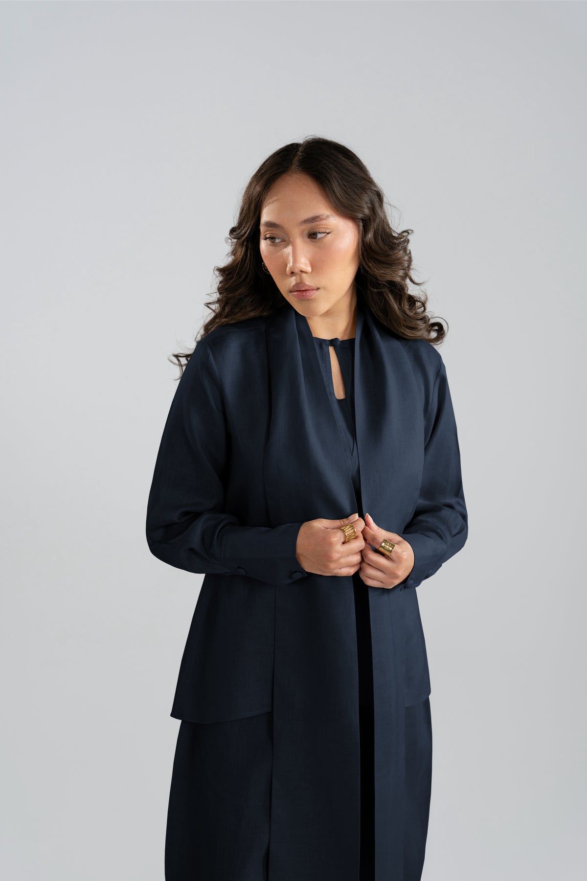 Woman wearing the Cove Set in navy blue, a pure linen three-piece co-ord set featuring a short shirt, panelled balloon trousers, and matching scarf from the linen collection.