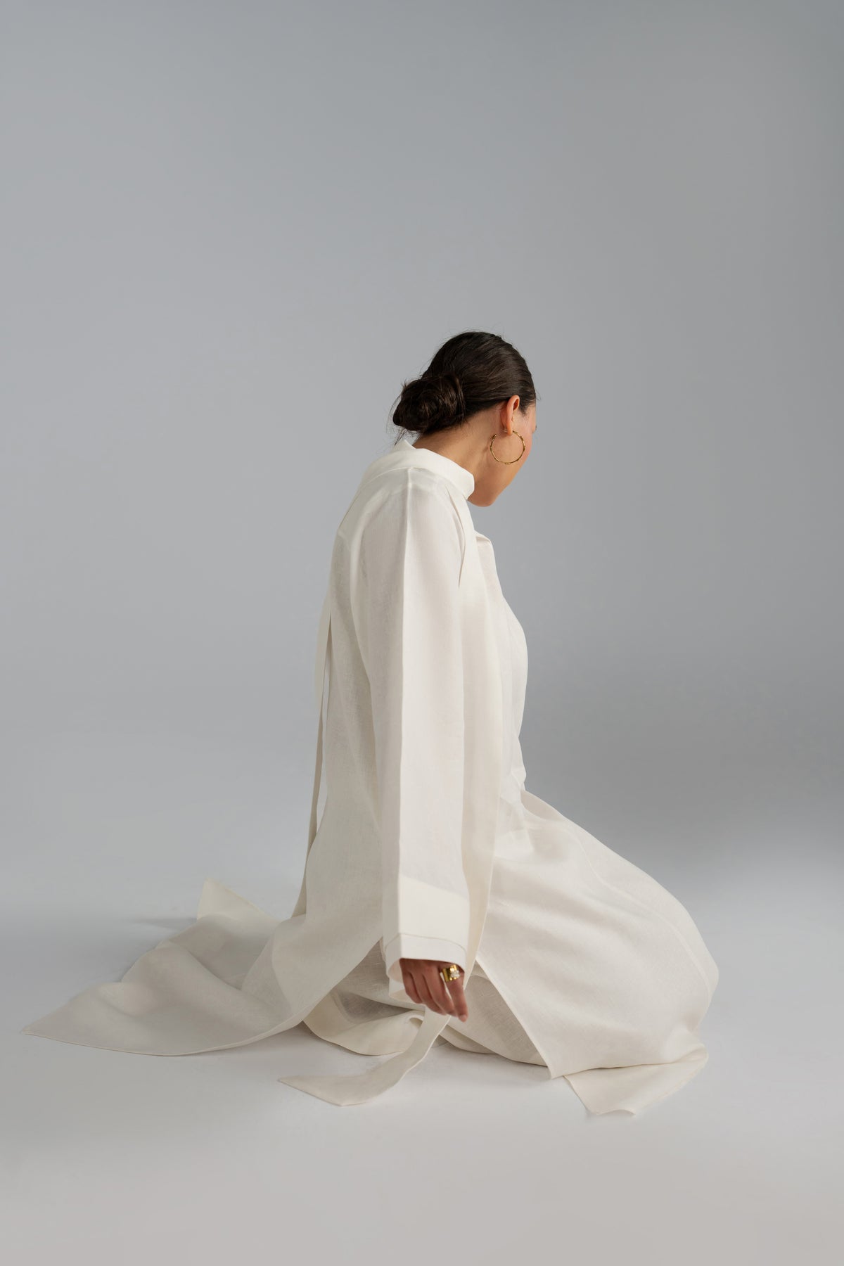 Kneeling pose in Mist Set tunic, fabric pooling detail