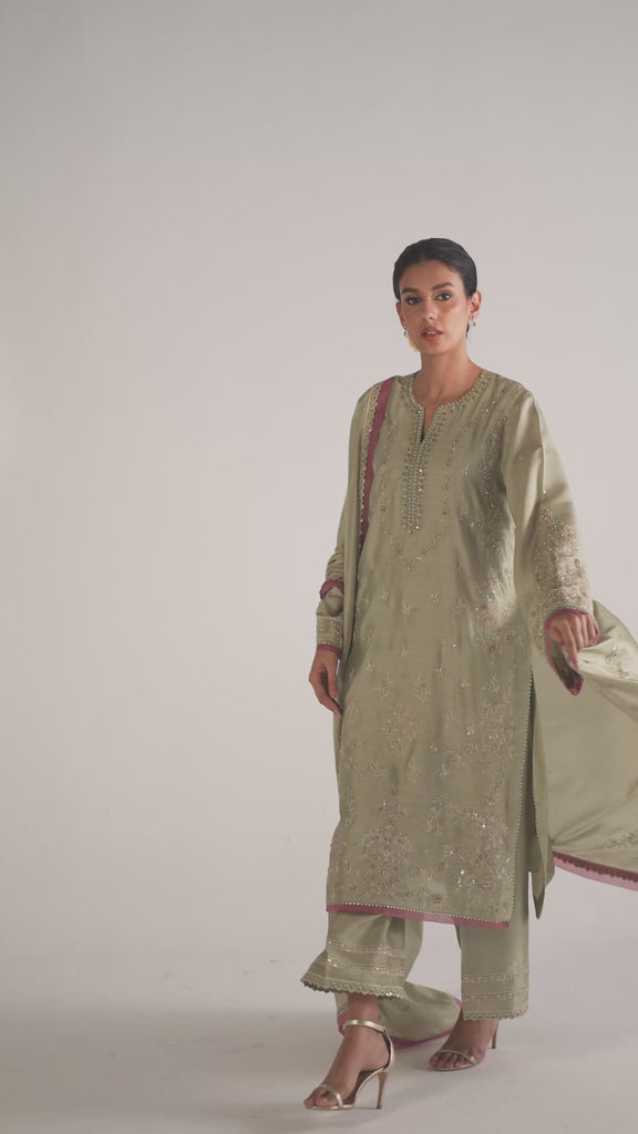 The Willow Set by Mannam is a pure khaadi silk kameez with intricate full-coverage hand embroidery, subtle mauve accents, gota embroidery detailing on sleeves and hem, and contrasting organza finishings. It comes with wide-hem raw silk trousers with multiple pleats and a hand-embroidered silk dupatta with organza finishings.
