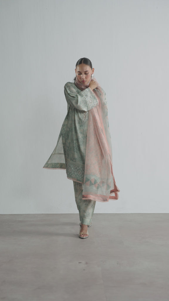 The Sky Blue Set by Mannam is a pure silk floral print short kameez with hand embellishments on the neckline, sleeves and hem, paired with a pure silk printed shalwar and a pure organza printed dupatta with gota detailing on the border.