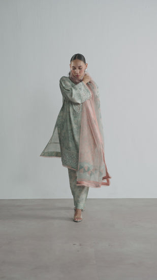 The Sky Blue Set by Mannam is a pure silk floral print short kameez with hand embellishments on the neckline, sleeves and hem, paired with a pure silk printed shalwar and a pure organza printed dupatta with gota detailing on the border.
